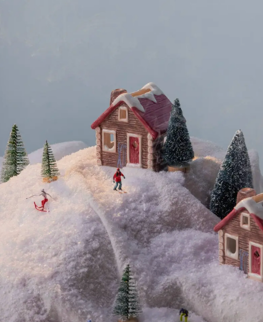 The Alpine Chalet incense burner et on a snowy hill in a diorama of a winter scene. 