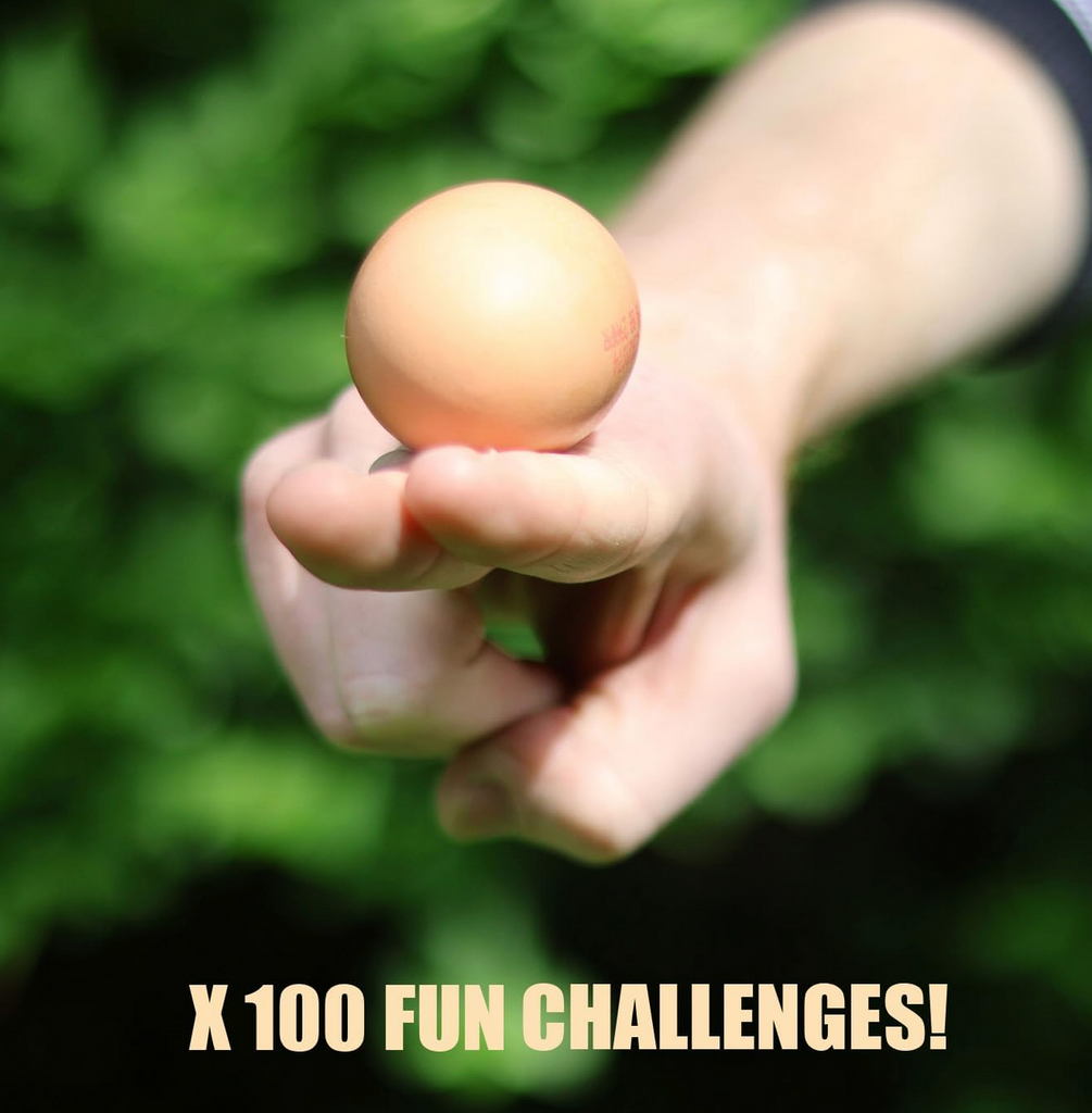 A hand balancing the fake egg on two fingers from The Egg Game challenge deck. 