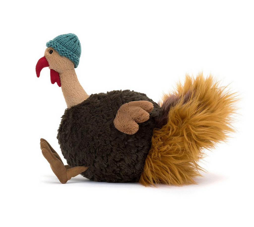 Plush toy turkey with a knitted hat on a white background