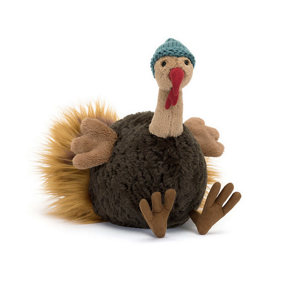 Theo Turkey stuffed animal from Jellycat with his big ol' feet, red wattle and green knit cap. 