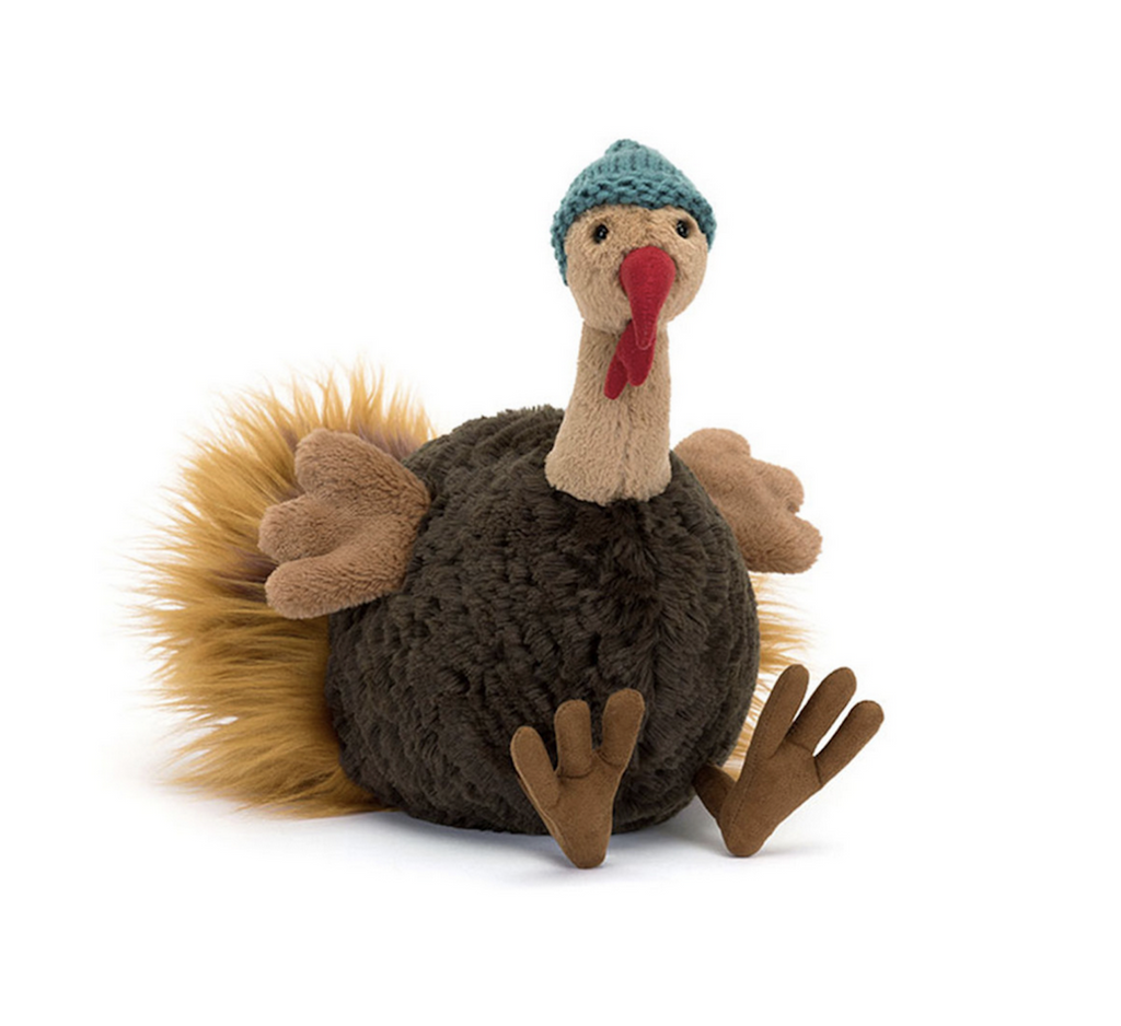 Plush turkey wearing a green hat on a white background
