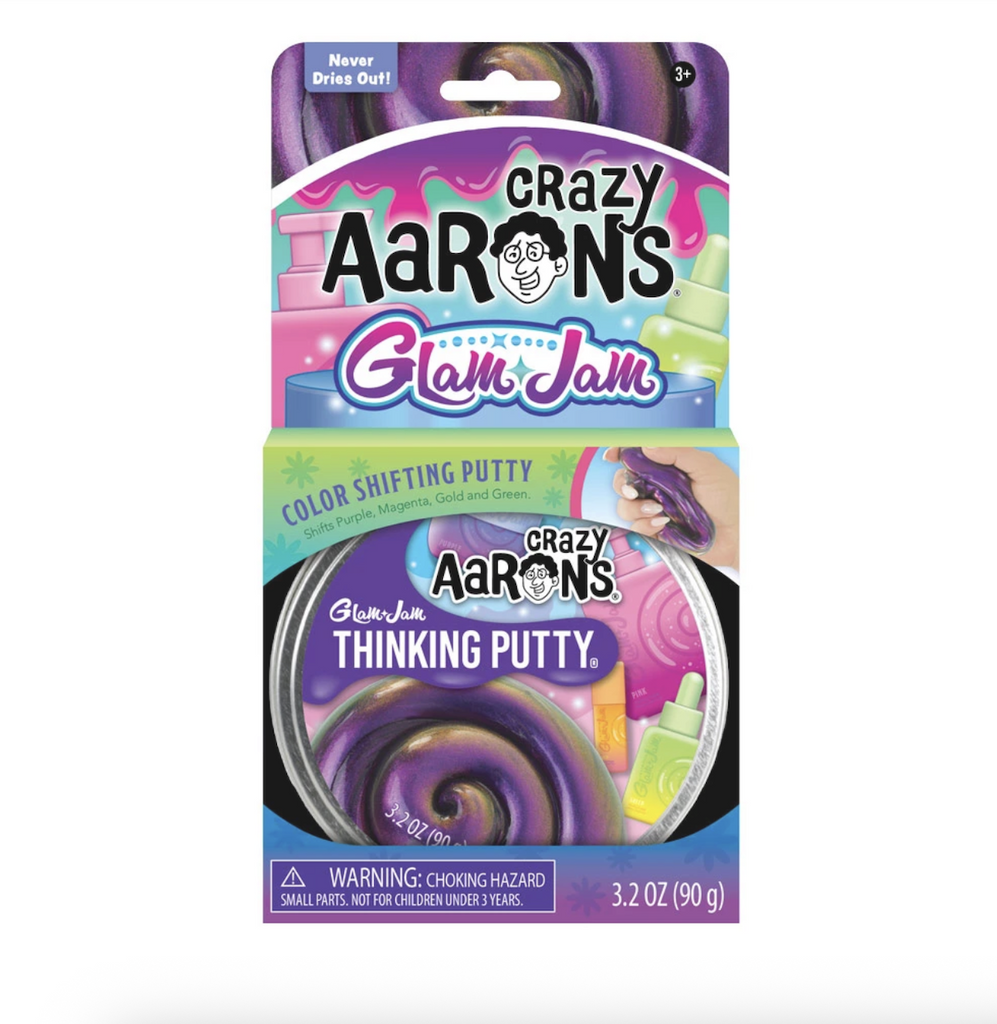 Crazy Aaron's Glam Jam Thinking Putty tin packaged in an open box that shows off the label featuring pink, purple and green colors that mimic the color shifting nature of the putty. 