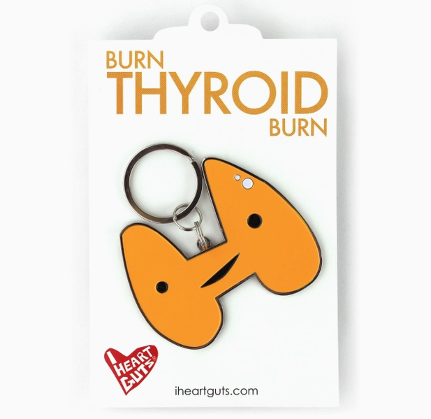 Thyroid enamel keychain with silver keyring on a white backing card.