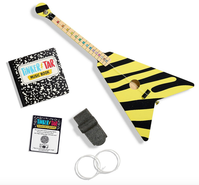 Everything included with the TinkerTar Rockstar guitar. The yellow and black flying v guitar, instruction book, shoulder strap and extra strings. 