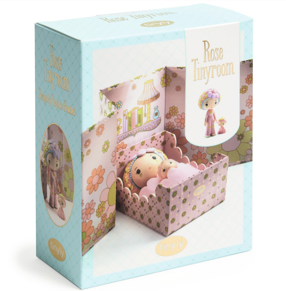 The packaging for the Rose Tinyroom from Tinyl. Pictured on the front of the box is Rose and companion Fleur snuggled together in the bed of the tinyroom. 