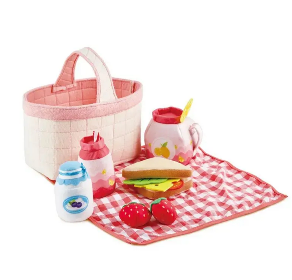 The pretend picnic spread with red plaid blanket and play foods. 