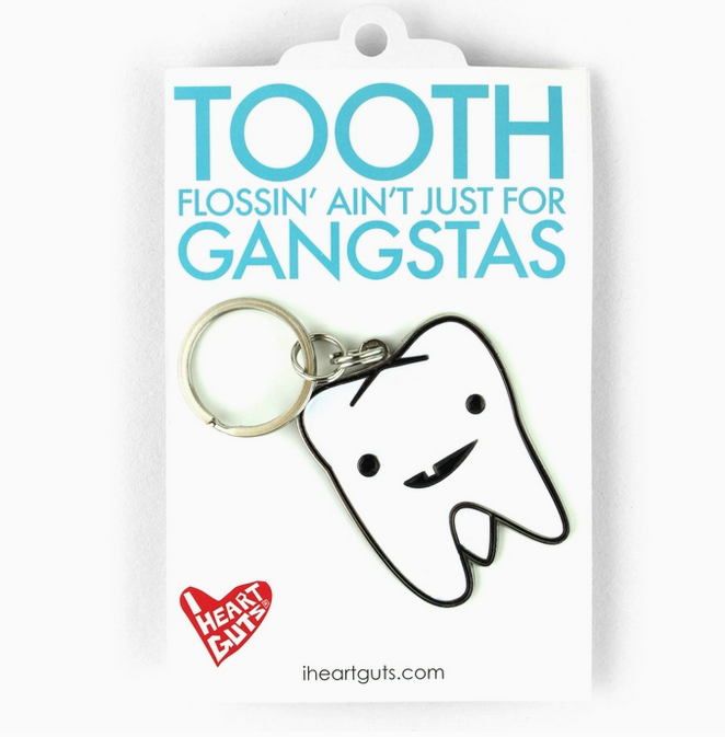 White enamel tooth shaped keychain with a silver keyringon a backing card.
