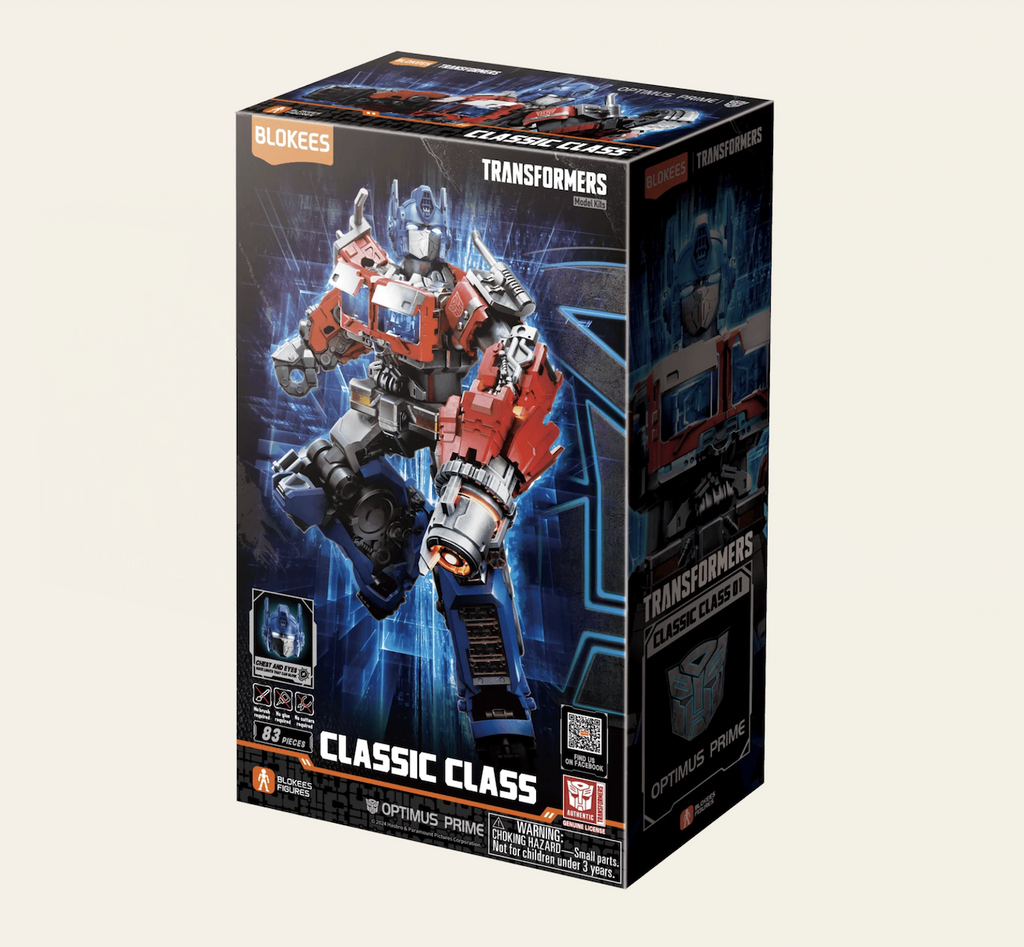 Transformers Optimus Prime model kit packaged in a black box with with pictures of the Optimus Prime model figure in different poses. There is white lettering at the bottom of the box that reads "Transformers Classic Class" 
