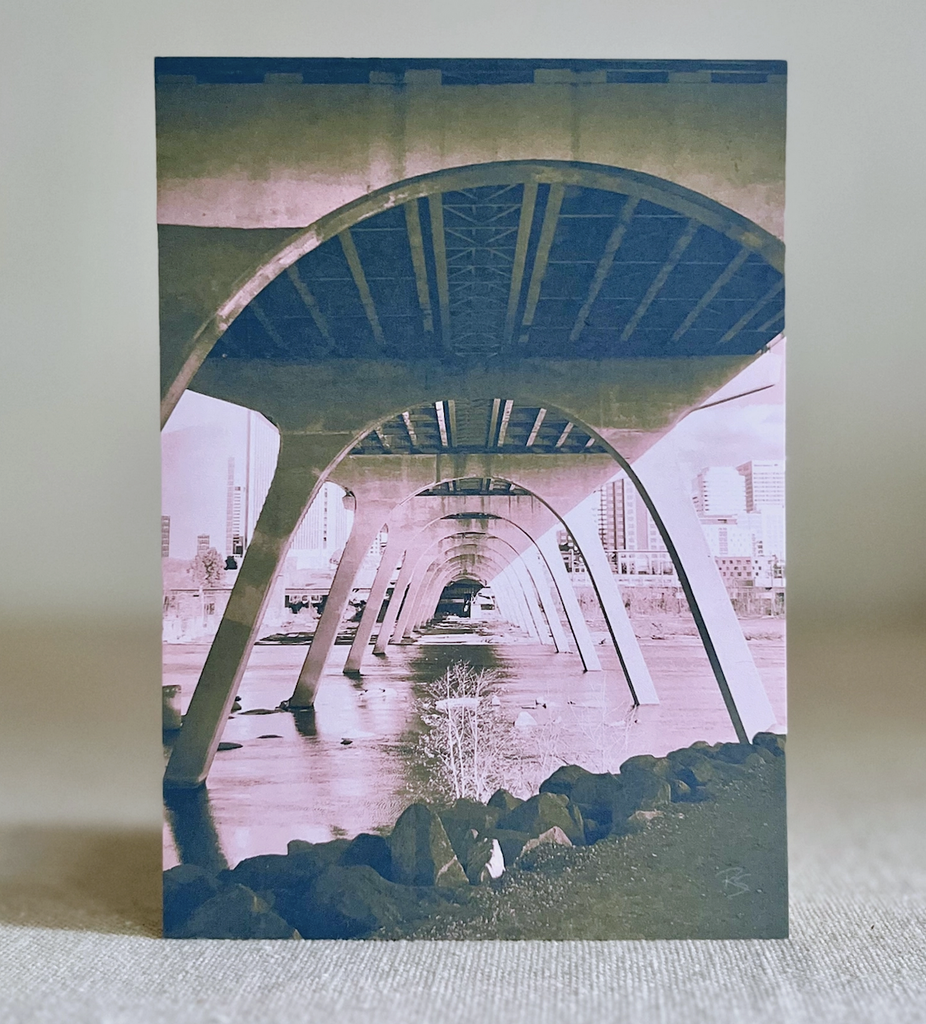 5x7 print of a photograph under a bridge that crosses the James River between Downtown and Manchester. The photo has been colorized in pink, green, and blue. 