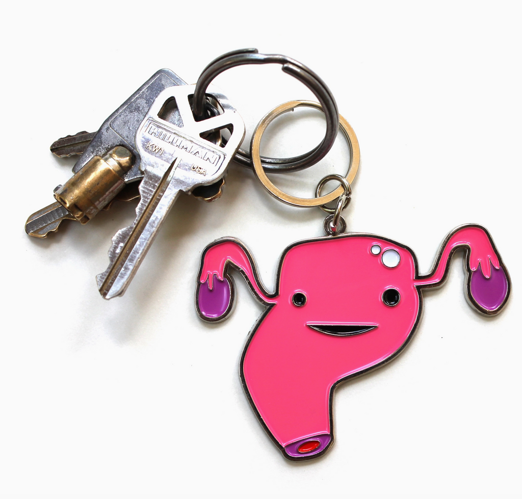Pink enamel uterus keychain with keys attached.