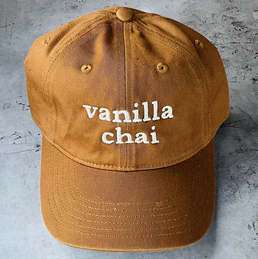 Coffee colored ball cap with Vanilla Chai embroidered on the front in white. 