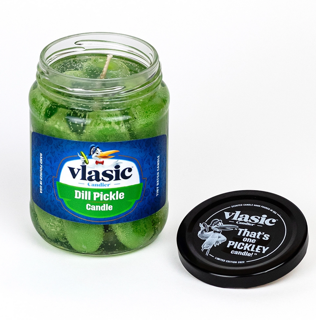Vlasic dill pickle candle in a jar with a black lid beside it. 