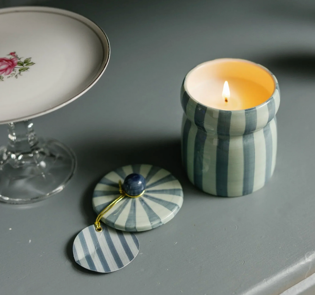 Warm cider scented candle in a light blue and teal striped ceramic holder. 