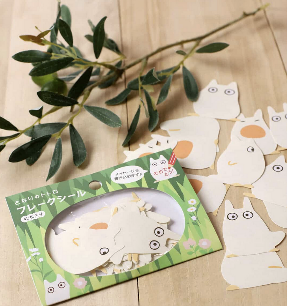 White Totoro shaped sticky notes in package and loose on a table.