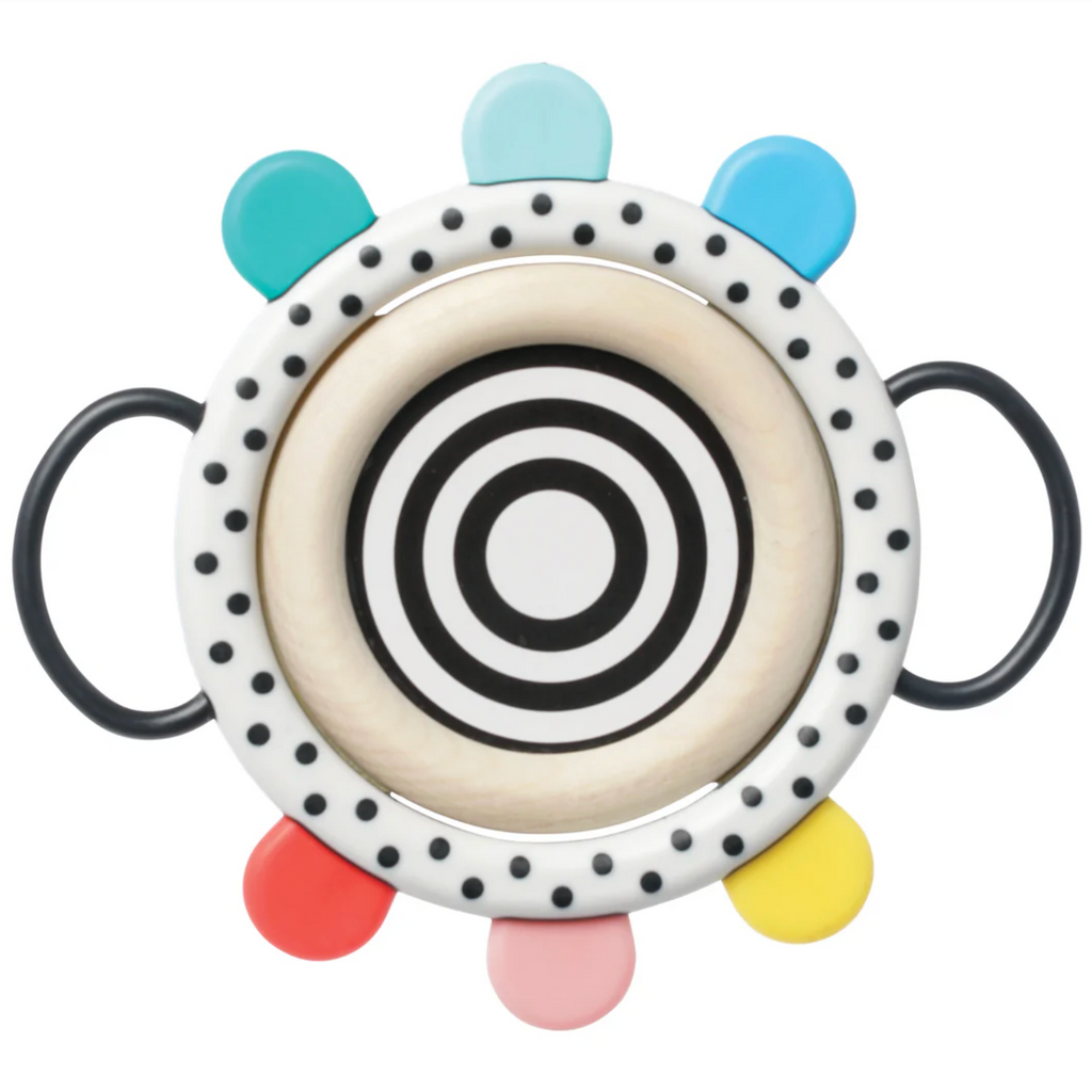 Back side of the Wimmer Grasp and See Mirror which is a black-and-white bullseye in the center and black polka dots on a white circle surrounding the mirror. 