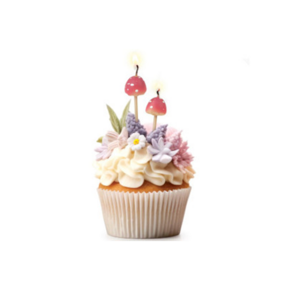Frosted and decorated cupcake with two of the mushroom candles. 