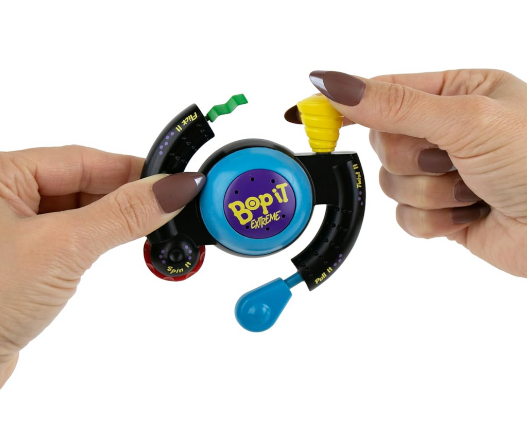 Person holding a colorful 'Bop It! Extreme' miniature electronic game device.