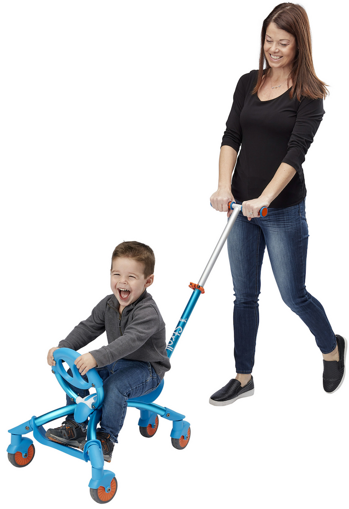 A toddler riding the Ybike Pewi Stroll with a parent pushing him along. 