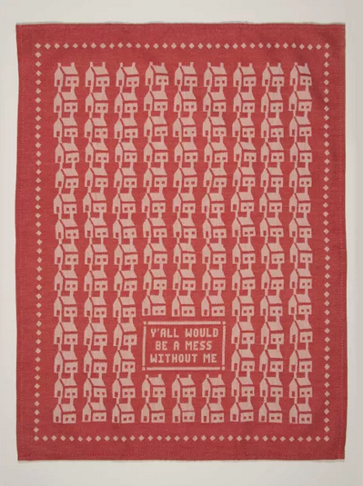Dishtowel spread out with white houses in a repeating pattern on a red background. It reads "Y'all would be a mess without me" 