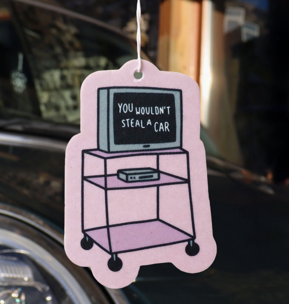 Air freshener shaped like a t.v. on a tall rolling cart hanging in a vehicle. 