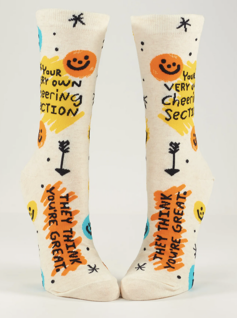 Cream colored knee socks with orange and yellow smiley faces and squiggles that read "Your Own Cheering Section, They Think You're Great"