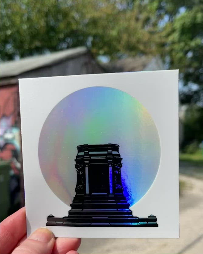 video of hand holding sticker moving so show the holographic effect on the sticker.White square vinyl sticker with an image of the former Lee Monument pedestal minus the former statue on top in black in Richmond, VA. Behind the pedestal is a holographic silver circle. That area is now called Marcus-David Peters Circle.