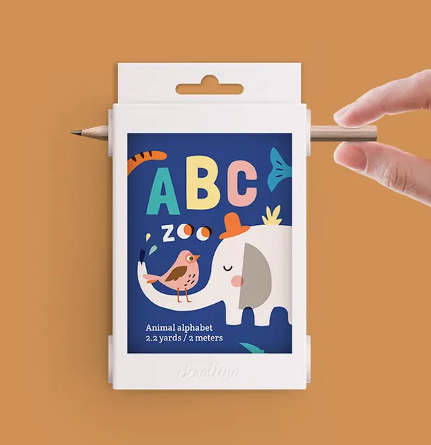 Box of ABC Zoo Scrollino animal alphabet box with a hand turning a pencil in the side of the box making the paper move.