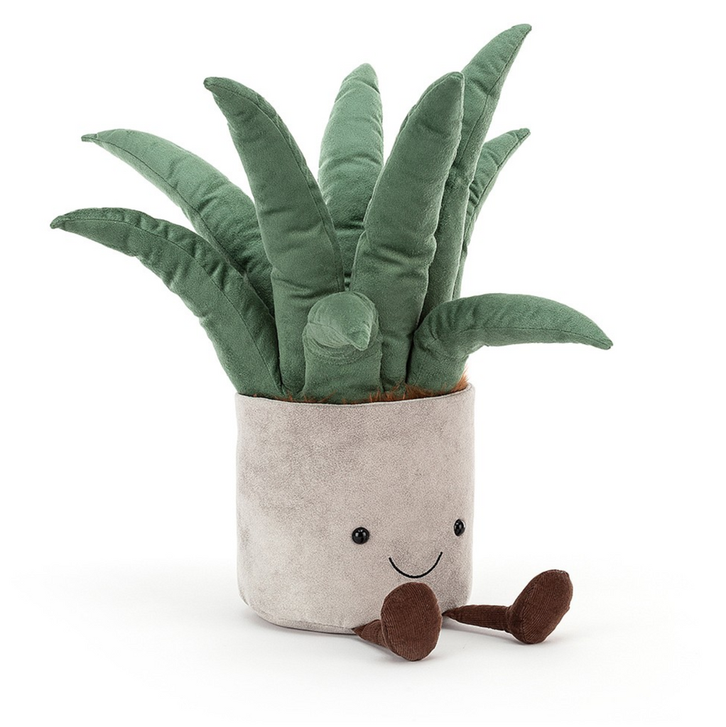 Jellycat Aloe Vera Amuseable plush plant. Thick aloe leaves sit in a light colored plush pot with a smiling face and brown plush legs.