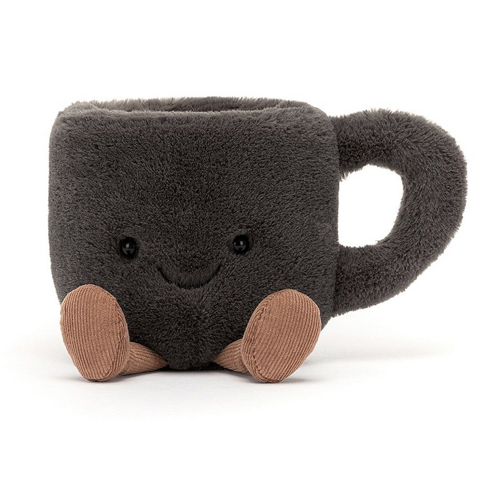 Dark grey plush coffee  mug with a smiling face and tan courduroy boots stretched out in front. 