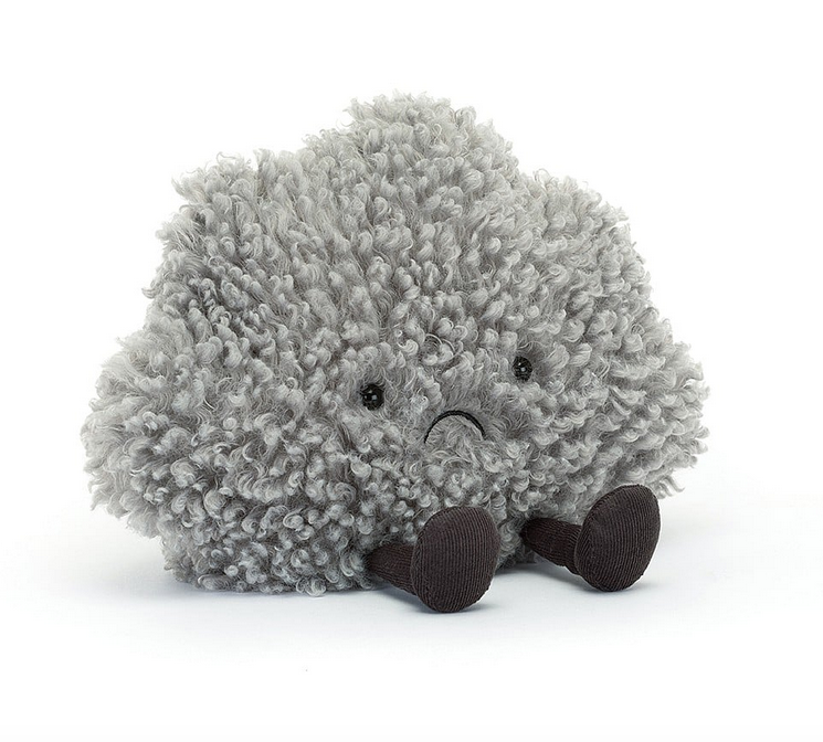 A little plush cloud with grey fuzzy, curly fur, dark brown legs and feet. He's frowning which only adds to the cuteness. 