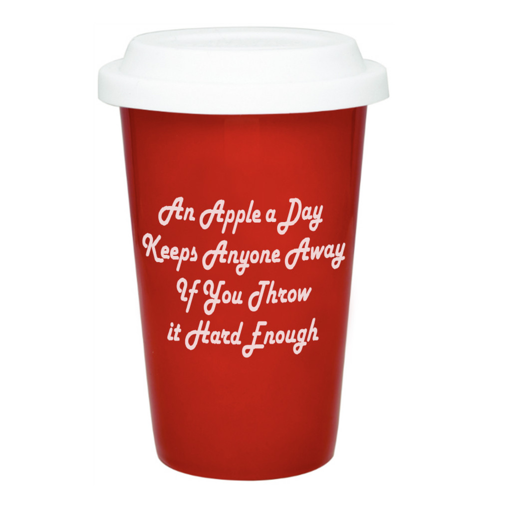 Red ceramic tumbler with a white silicone lid. White text reads "An apple a day keeps anyone away if you throw it hard enough."