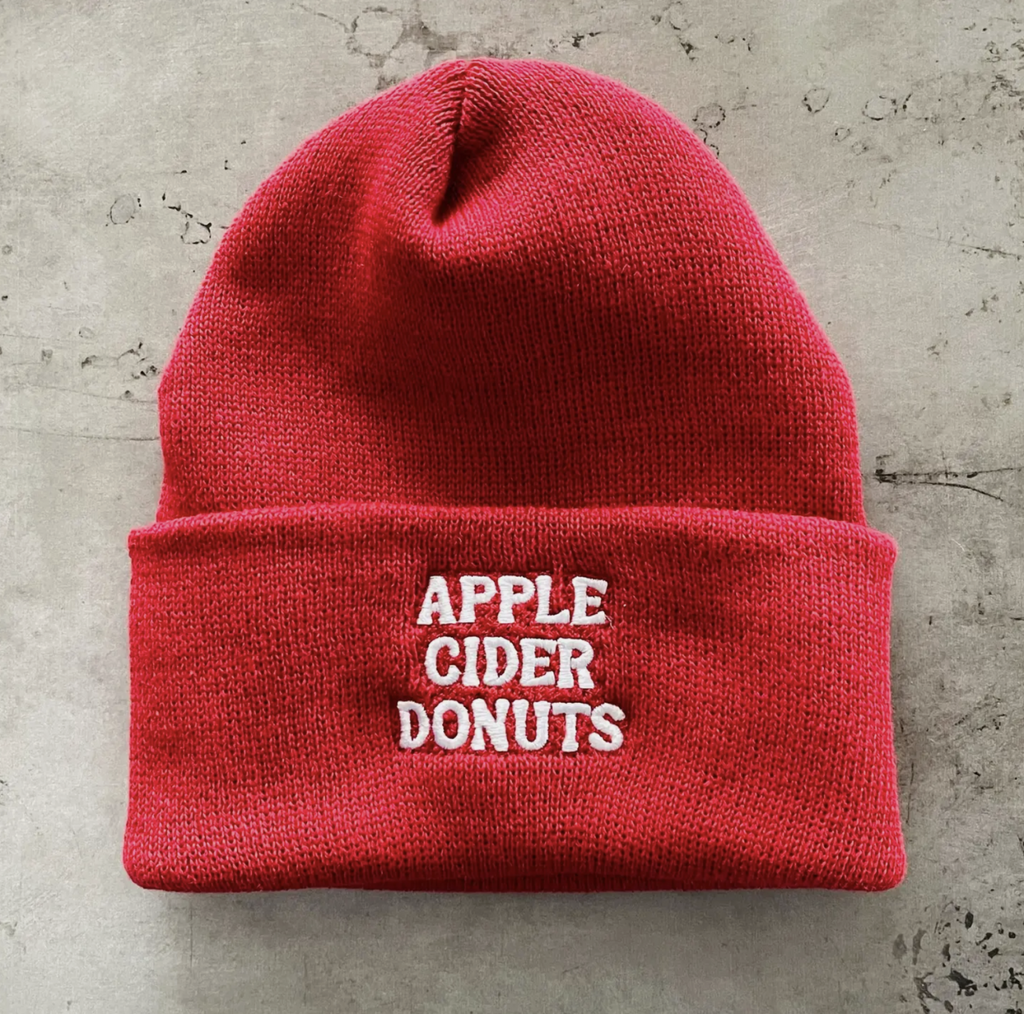 Red knit beanie with Apple Cider Donuts embroidered in white stitching. 