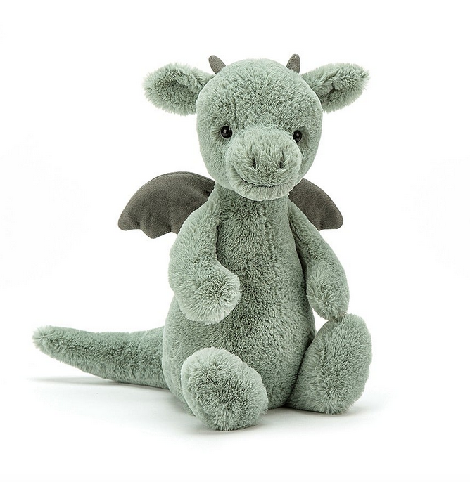 The Bashful Dragon plush facing forward and sitting up, you can just see his horns and the edges of his wings. 