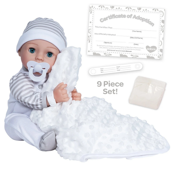   Gender-neutral baby doll set showing the 16" weighted baby doll, a Certificate of Adoption, a pacifier, a hospital bracelet, a disposable diaper and baby blanket. The baby doll is sitting up with the pacifier in it's mouth. 