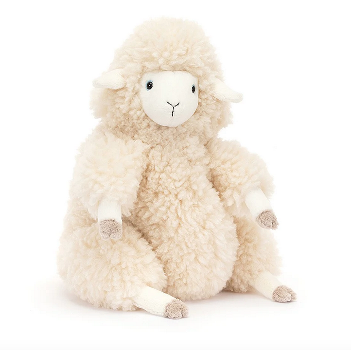Bibbly Bobbly Sheep sitting up and facing forward with fluffy and fuzzy cream colored fur and thr sweetest face. 