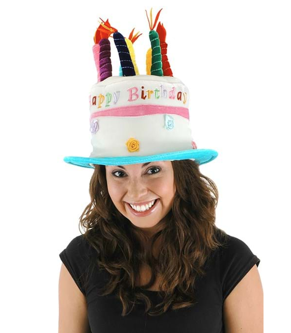 This hat is designed to look just like a birthday cake, complete with frosting and faux candles on top. It even has "Happy Birthday" written on the side of it. It is being worn by an adult. 