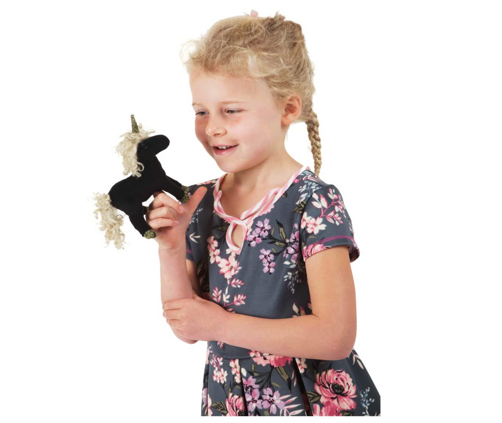 Child playing with mini black unicorn finger puppet.
