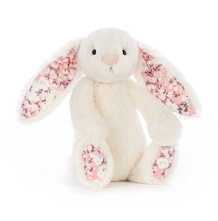 This small bunny has creamy white fur with a cherry blossom on it's paws and lining it's floppy ears. 