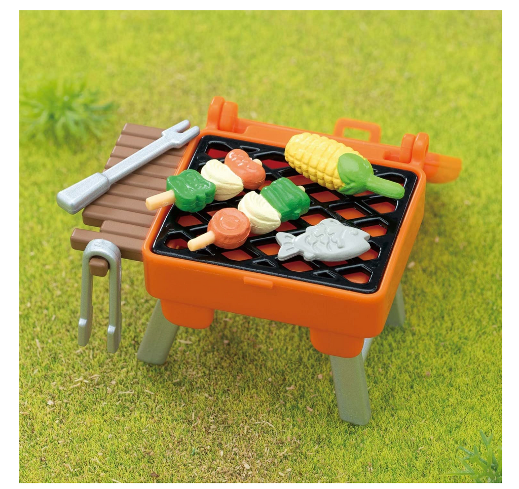 BBQ grill with ting kabobs, corn, fish, and utensils.