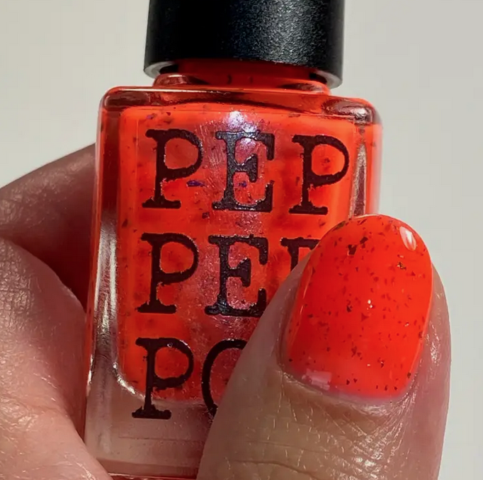 Bright orange with gold flakes Cats Against the Pawtriarchy nail polish.
