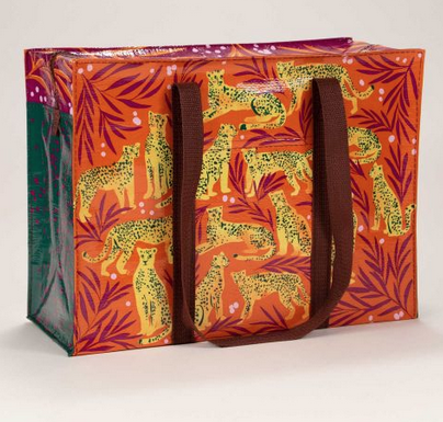 Shoulder tote with an orange background with brown branches and yellow cheetahs that are standing, laying, or sitting. 