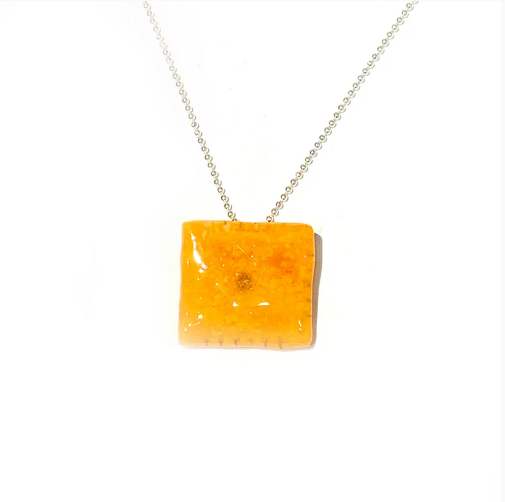 Real Cheez-It in resin charm on a silver chain necklace.