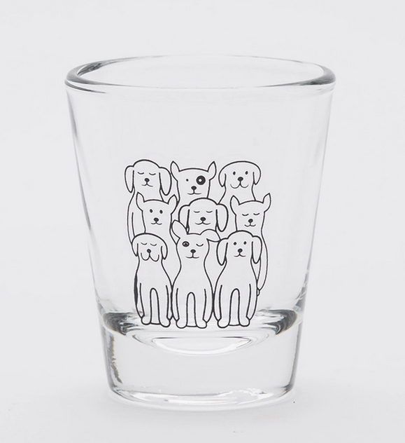 Clear 2oz shot glass with several dogs printed on it. 