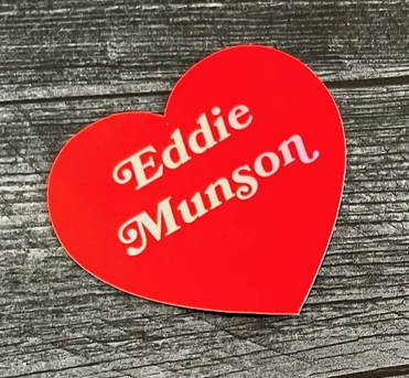 Red heart sticker that reads Eddie Munson in white.