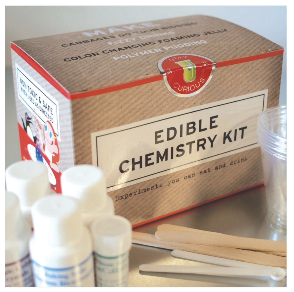 Edible chemistry box with bottles of experiment solution and popsicle stick tools in the foreground. 