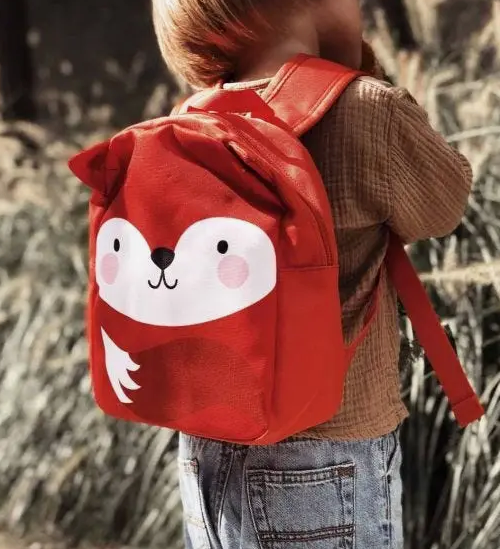 Child wearing fox mini backpack.