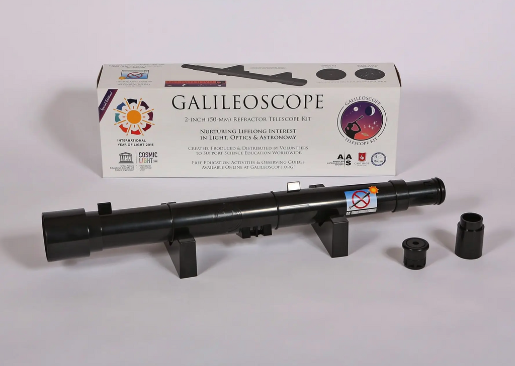 Refractor telescope on stand with lenses and display box.