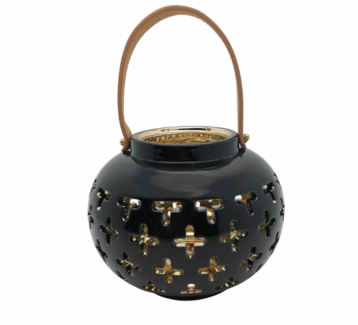 Black cutout ceramic lantern with shiny golden interior.