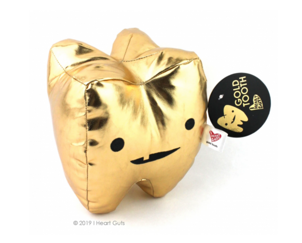 Shiny gold metallic tooth shaped plush with eyes and a toothy grin. 