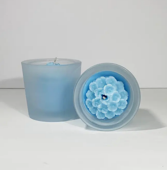 Hydrangea flower candles. Top view showing the intricate flower design and the other showing the frosted glass container. 